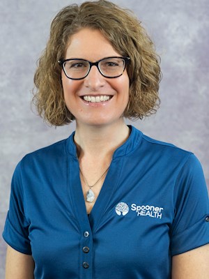 mavis-melton Mavis Melton, PT, wearing Spooner Health branded attire, smiling against a neutral background, representing her role as a physical therapist specializing in injury treatment and rehabilitation.