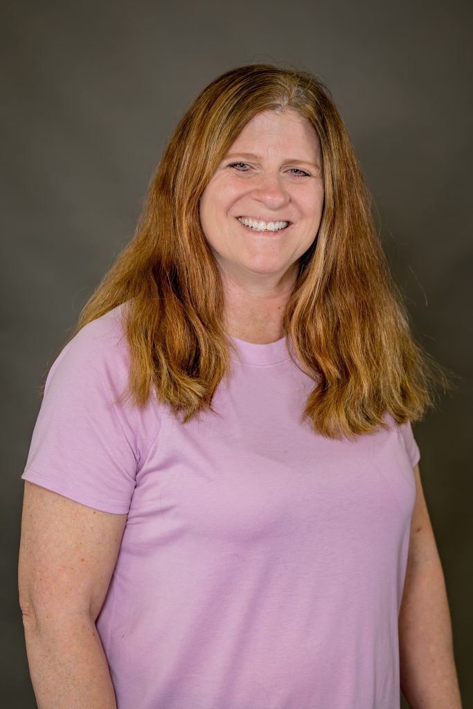 Cori Miller, OTR, smiling in a pink shirt, representing Spooner Health's Occupational Therapy services focused on enhancing mobility and quality of life.