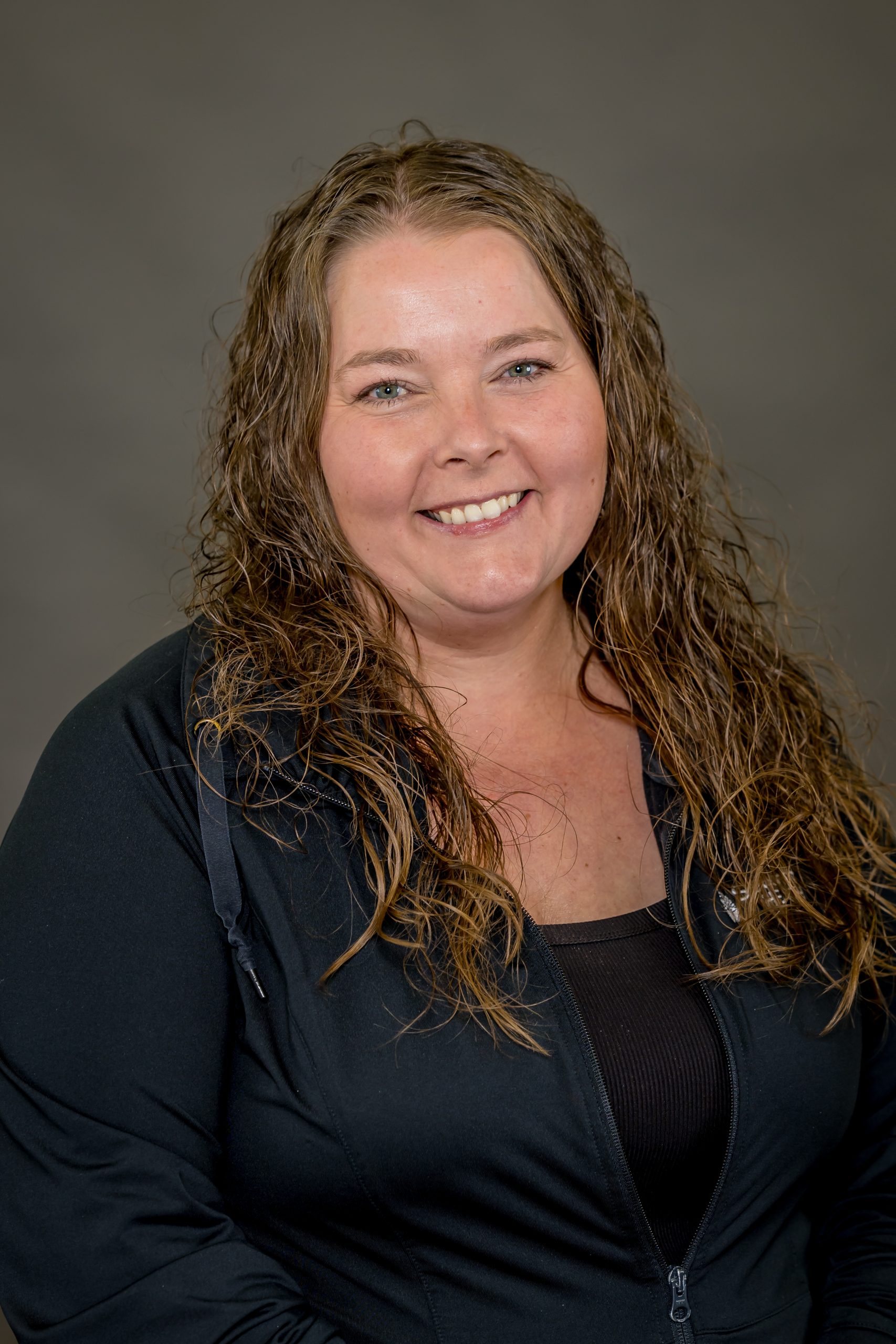 Erin VanGuilder, Certified Occupational Therapy Assistant, smiling in a black jacket, showcasing her role in rehabilitation services at Spooner Health.