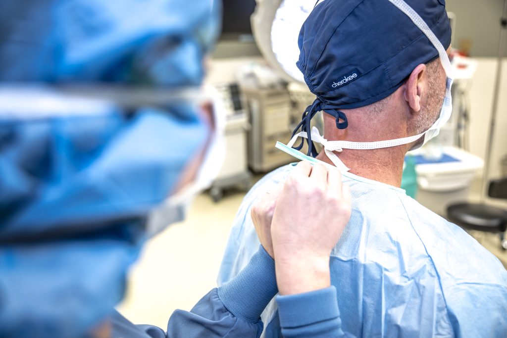 Surgical team preparing for procedure, healthcare professionals in scrubs discussing patient care, emphasizing surgical readiness and patient engagement.